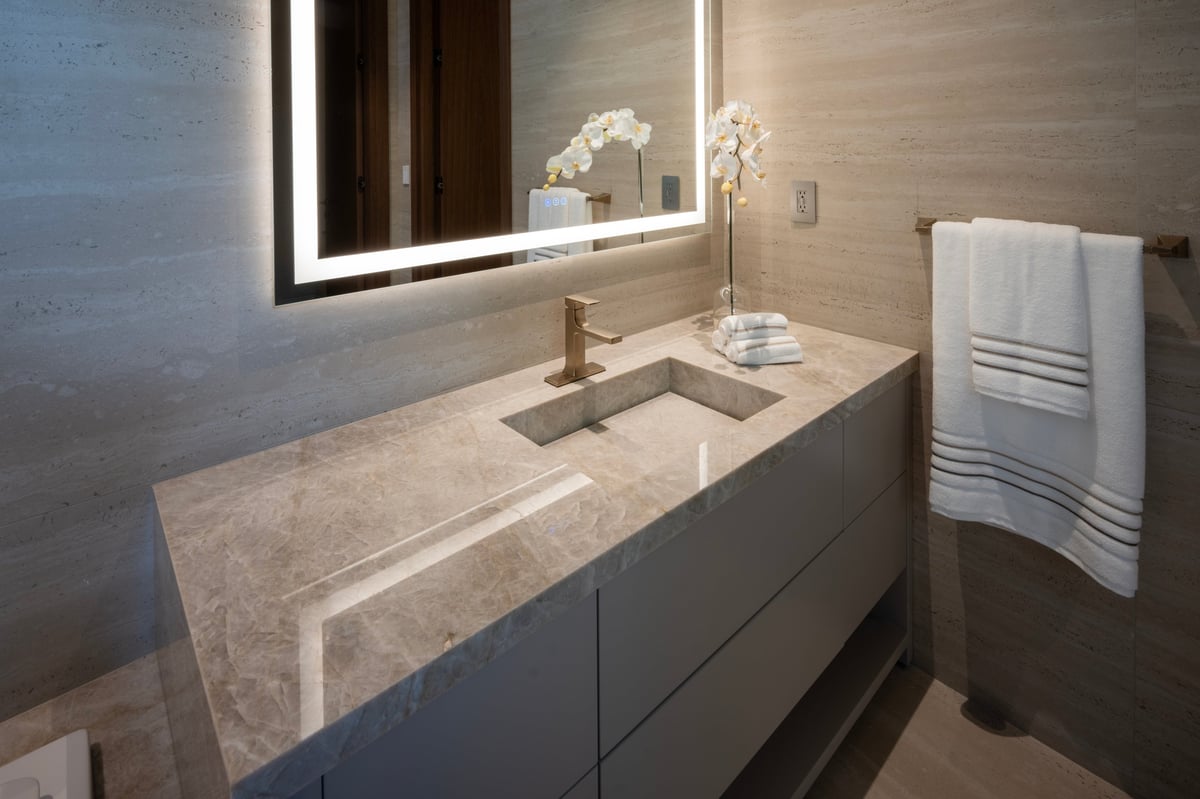 Modern luxury bathroom vanity with an integrated marble sink and brass faucet